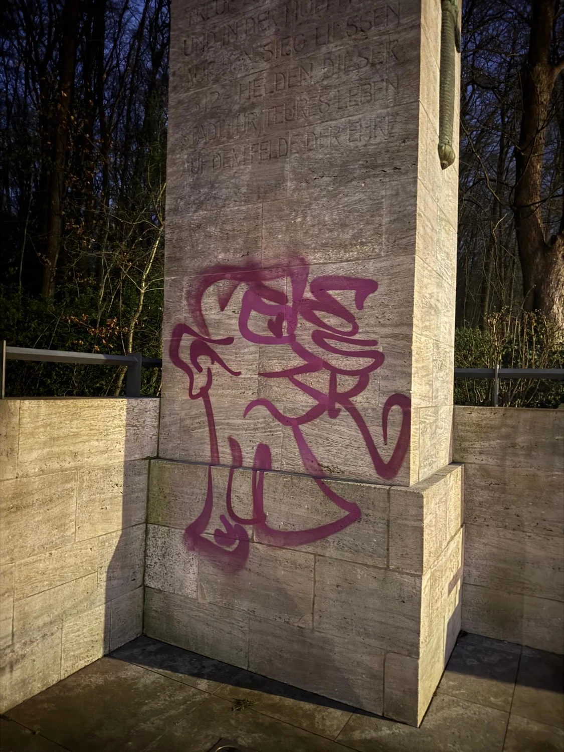 Christoph Mielke - Hausmeister Service & Graffitientfernung - Dieses Bild zeigt lila Graffiti auf einem Steindenkmal oder einer Mauer.