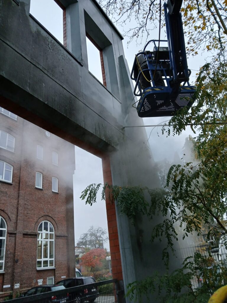 Außenwand Reinigung mit Hochdruckreiniger Mitarbeiter auf Hebebühne führt Reinigung aus